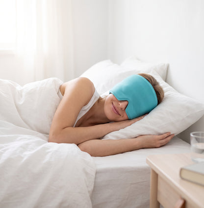 Mujer descansando en la cama con el gorro de gel para migraña en color turquesa